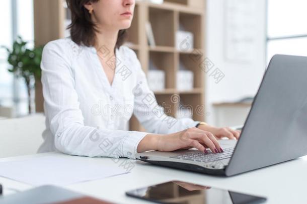 办公室工人打字,工作的在她工作场所,使用便携式电脑.