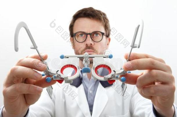 眼镜商手和试验框架,验光师医生仔细检查眼睛