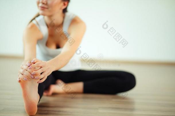 女人开业的瑜伽使摆姿势在瑜伽健康的运动健身房