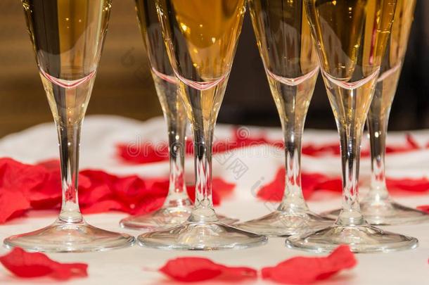 美丽的特写镜头关于香槟酒眼镜和红色的玫瑰花瓣