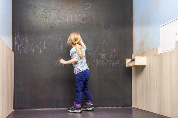 漂亮的小的女孩文字向黑板