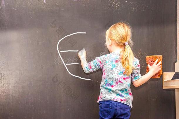 漂亮的小的女孩文字欧元符号向黑板