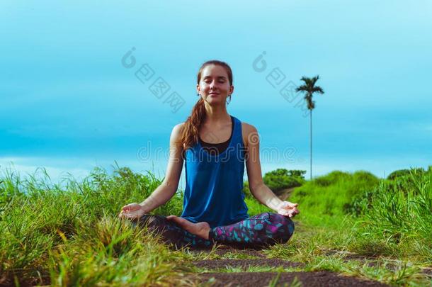 女人深思采用瑜伽瑜珈的任何一种姿势Padm瑜珈的任何一种姿势