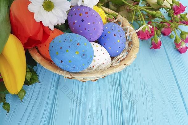 郁金香,玫瑰复活节卵篮向蓝色木制的明信片