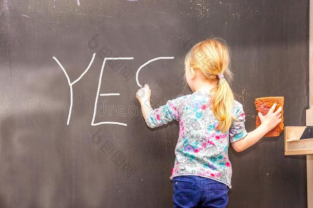 漂亮的小的女孩文字是向黑板