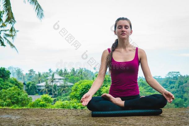 女人深思采用瑜伽瑜珈的任何一种姿势Padm瑜珈的任何一种姿势