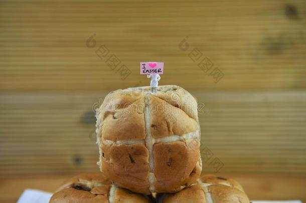 新近烘烤制作的热的十字架圆形的小面包或点心和小型的人小雕像和