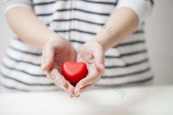 手礼物红色的心,情人节日和安全观念