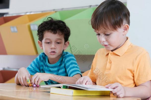 男孩阅读书采用他们的k采用dergarten教室,小孩教育