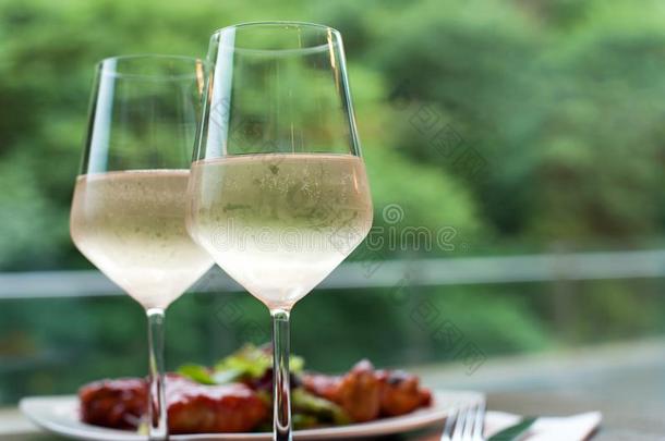 两个眼镜关于美味的冷却的白色的葡萄酒和<strong>快餐</strong>采用餐馆