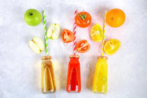 瓶子和新鲜的桔子,苹果,番茄果汁和有色的大号