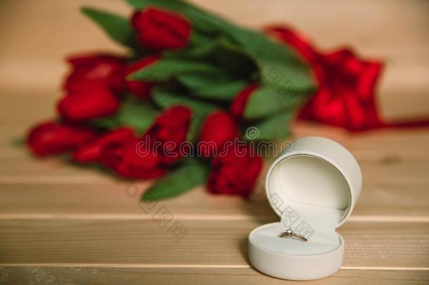 花束关于红色的郁金香和钻石戒指为结婚