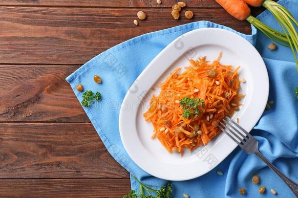 白色的盘子和很好吃的胡萝卜葡萄干沙拉向漂亮的蓝色餐巾