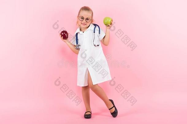 小的女孩采用医生戏装和苹果