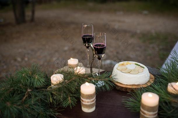 两个玻璃和红色的葡萄酒,婚礼蛋糕和一份额关于c和les布置
