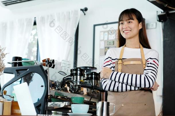 年幼的亚洲人女人咖啡馆准备咖啡的<strong>员工</strong>起立和微笑的面容采用字体关于