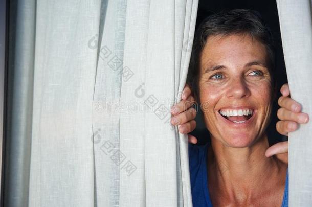 关在上面幸福的女人开幕窗帘和有样子的通过窗