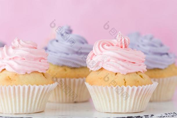 纸杯蛋糕和粉红色的和紫罗兰甜奶油酱st和ing向彩色粉笔钉