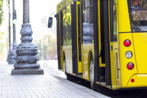 现代的黄色的城市公共汽车和敞开的门在公共汽车st在ion