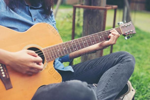 音乐家女人和她吉他采用自然公园,练习吉他.