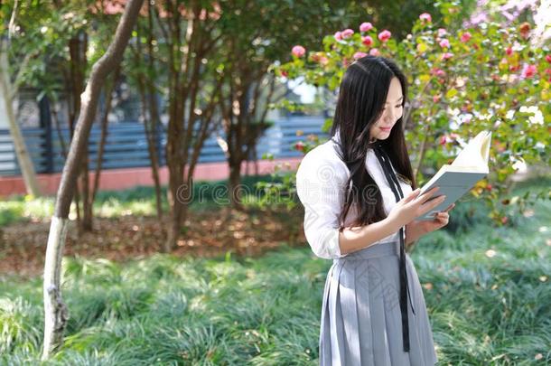幸福的亚洲人中国人漂亮的女孩穿着学生一套外衣采用学校阅读
