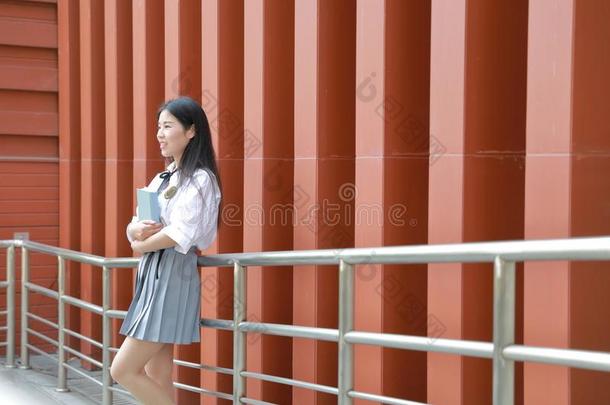 幸福的亚洲人中国人漂亮的女孩穿着学生一套外衣采用学校阅读