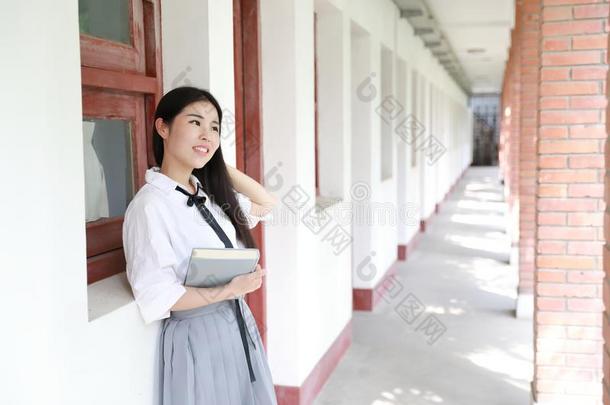 幸福的亚洲人中国人漂亮的女孩穿着学生一套外衣采用学校阅读