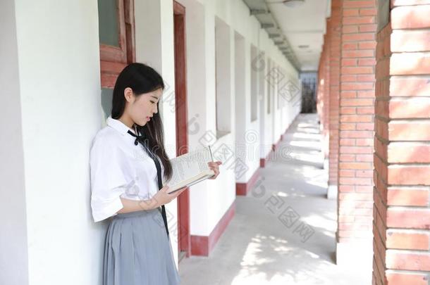 幸福的亚洲人<strong>中国</strong>人漂亮的女孩穿着学生一套外衣采用学校<strong>阅读</strong>