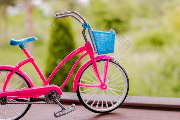 小的粉红色的自行车模型向指已提到的人栏杆和花园背景.