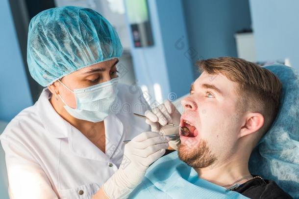 概观关于牙齿的<strong>龋齿预防</strong>.男人在指已提到的人牙科医生`英文字母表的第19个字母椅子