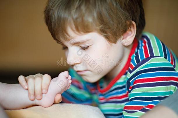 小的小孩男孩接吻的和演奏和脚关于新生的婴儿.