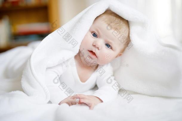 婴儿女孩使人疲乏的白色的毛巾或冬奥瓦尔采用白色的和煦的：照到阳光的是
