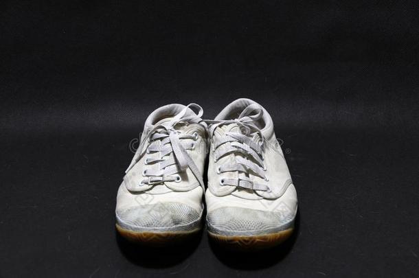 用过的旅游鞋鞋子采用白色的颜色但是它沾满污垢的和黑暗的颜色