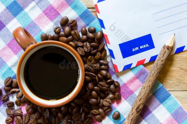黑的咖啡豆采用杯子和咖啡豆豆和邮件纸向木制的