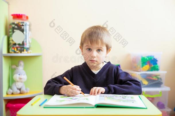 肖像关于漂亮的男孩和草图笔和书在书桌采用班级