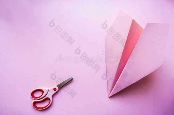 纸水平和剪刀向粉红色的背景.
