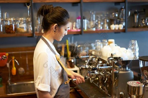 年幼的物主咖啡馆准备咖啡的员工准备的机器在咖啡豆商店,Prepar在ion