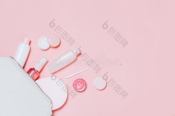 粉红色的装饰的化妆品和化妆品袋向粉红色的背景.
