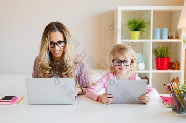 妈妈和女儿使用现代的技术同时