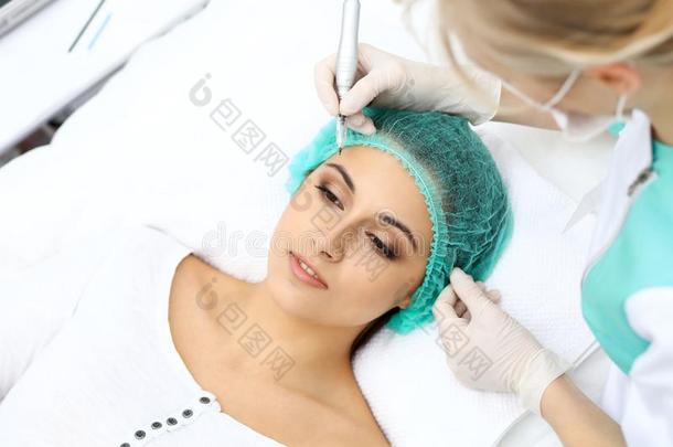 专业的美容师做眉毛文身在女人面容.电烫发