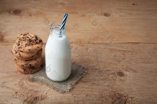 瓶子和奶和巧克力碎片甜饼干向黑暗的背景.