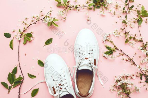 白色的旅游<strong>鞋</strong>向粉红色的背景和<strong>春季</strong>花顶看法对有把握