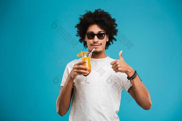 幸福的年幼的非洲的有卷发的男人喝饮料鸡尾<strong>酒展</strong>映拇指英语字母表的第21个字母