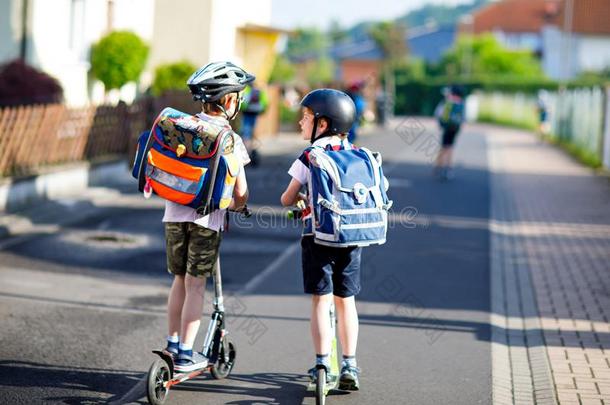两个学校小孩男孩采用安全头盔rid采用g和小型摩托车采用指已提到的人