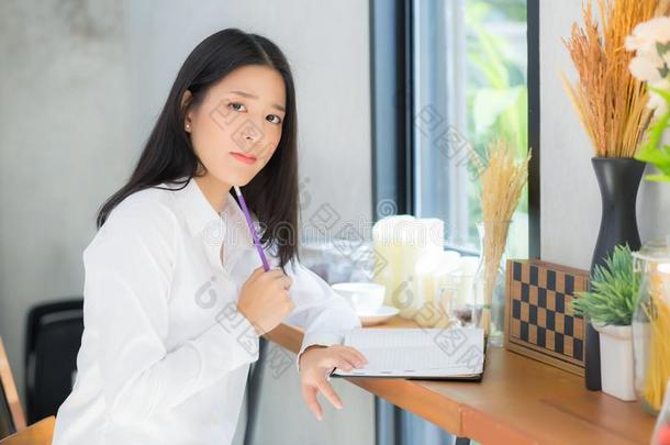 美丽的亚洲人年幼的女人工作的在线的和便携式电脑和想
