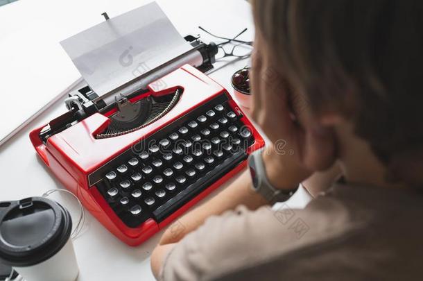 女人作家沉思地工作的向一书向她书桌红色的类型