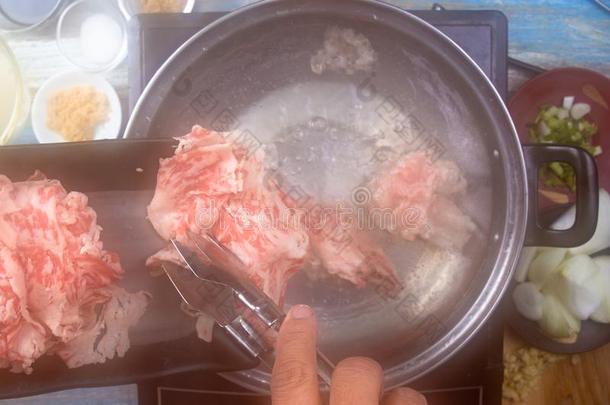 厨师烫伤牛肉和热的水为烹饪术