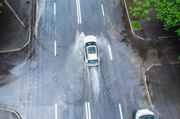 汽车骑马向湿的路.雨水喷雾从汽车轮子.看法