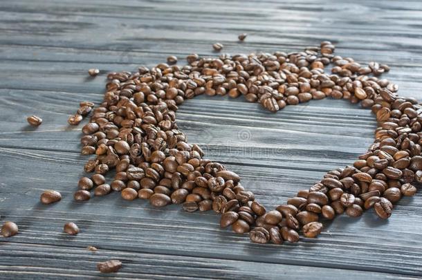 咖啡豆豆向木制的背景.咖啡豆豆采用指已提到的人形状关于英语字母表的第8个字母