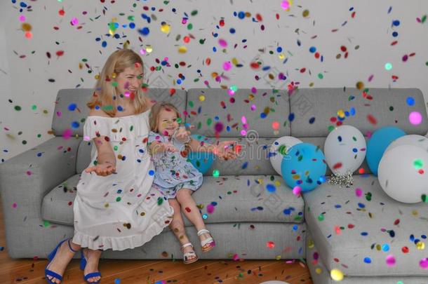 母亲和女儿庆祝生日和气球和五彩纸屑